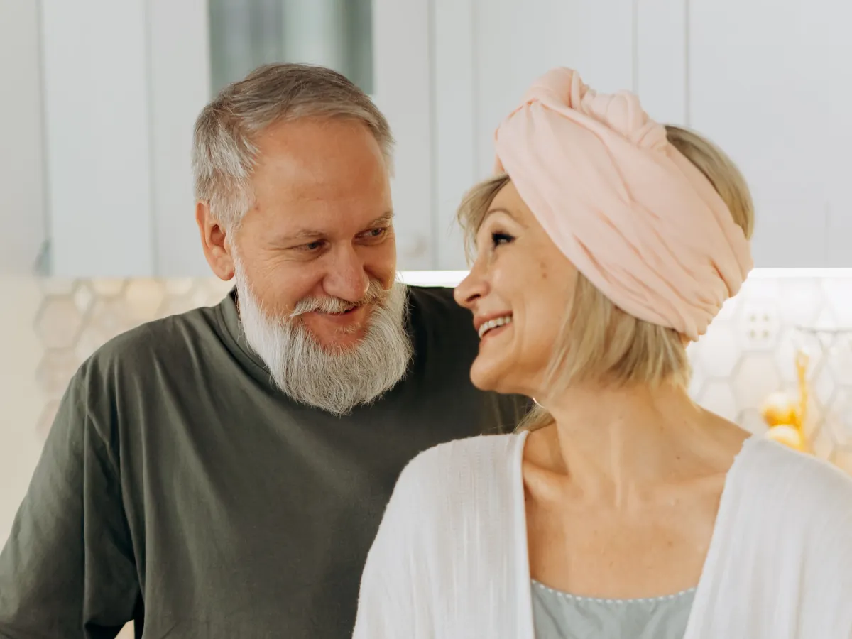 An older couple smiling together in their kitchen